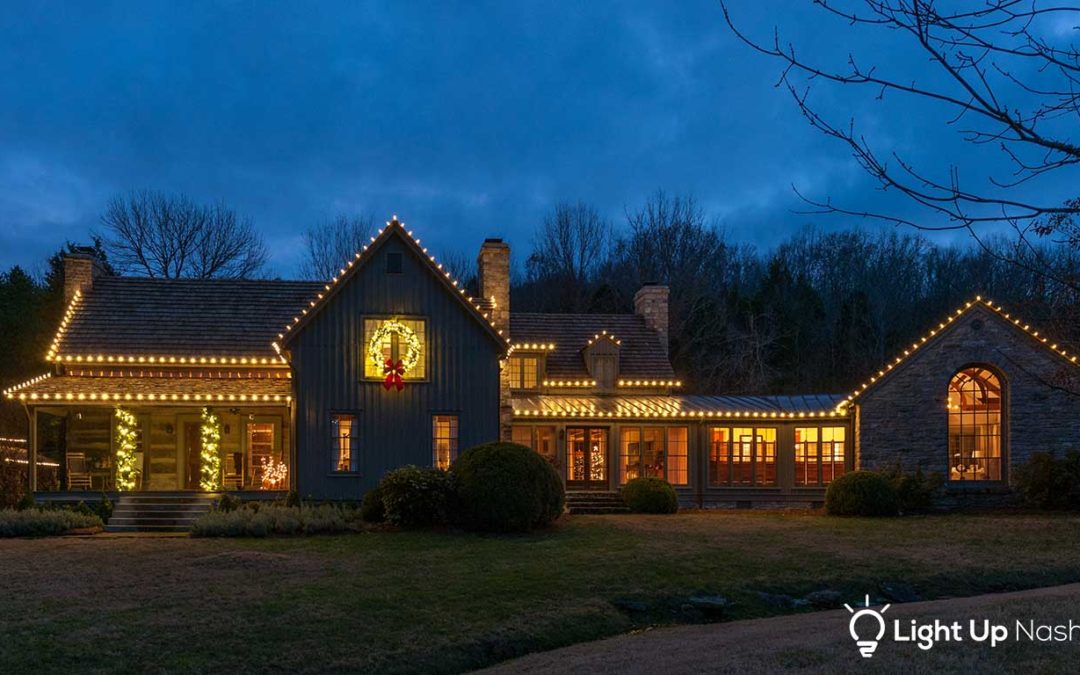 large home in Nashville with custom holiday lights on roofline and lit greenery
