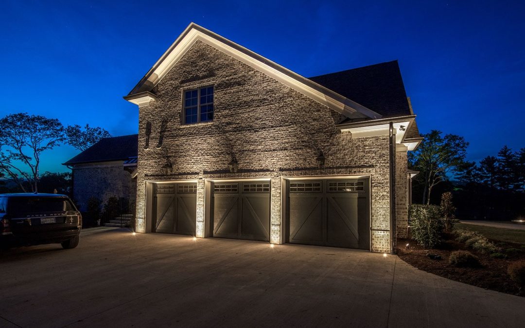 Outdoor lights, recessed into concrete driveway up lighting the garage facade