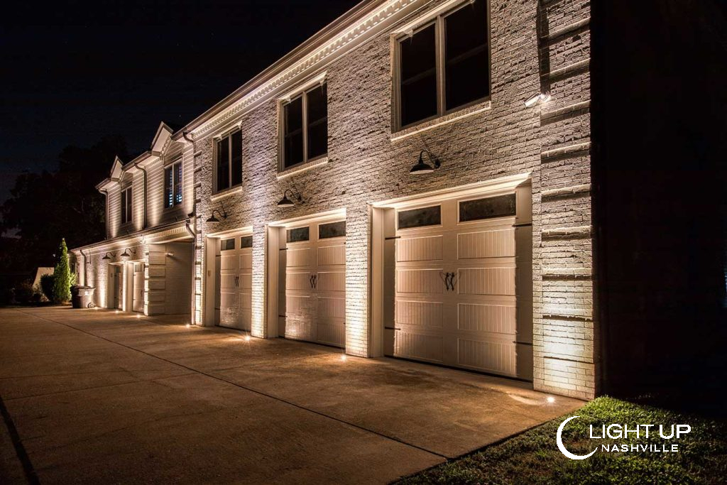 Flush mounted lights installed in existing concrete driveway up lighting facade of home.