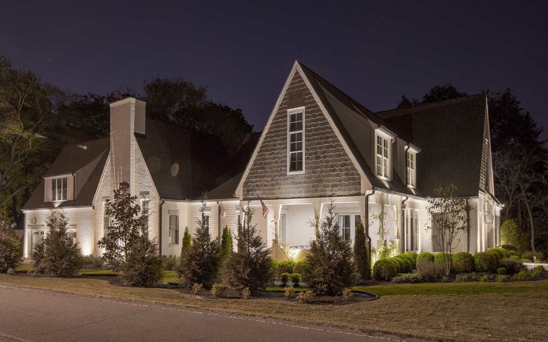 landscape lighting on white brick home exterior